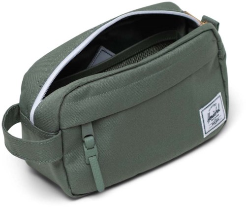 A green bag with a zippered main compartment, a handle, and a white label on the front.