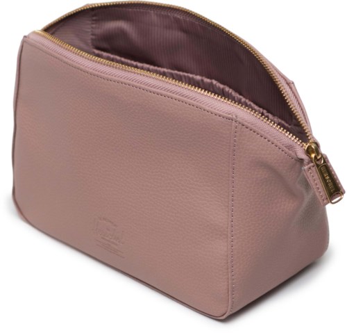 Ett mjukt rosa väskor med guldzipper. Det har en framficka och ett rymligt inre fodrat med tyg.
