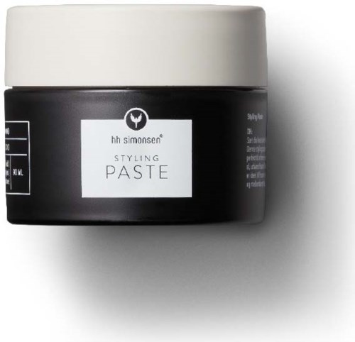 En svart krukke med hvit lokk og etikett, merket "Styling Paste" for hårstyling.