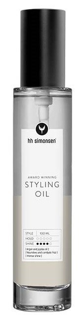 En genomskinlig flaska med svart lock innehållande stylingolja, med en vit etikett som visar varumärke och produktdetaljer.
