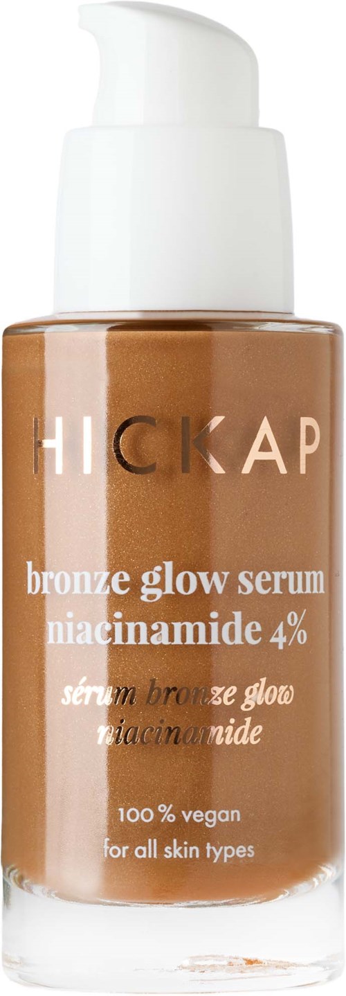 En flaska bronzig glow-serum med vit pump, märkt som vegansk, för alla hudtyper, innehåller niacinamide 4%.