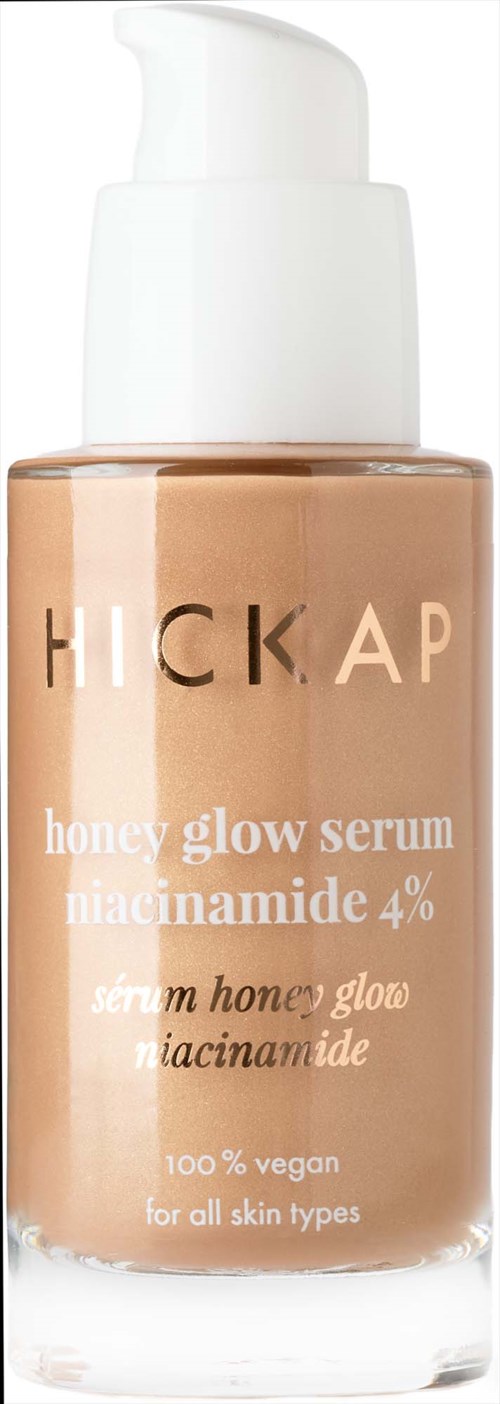 En flaska med honey glow serum med pump, märkt för alla hudtyper, vegansk, innehåller niacinamide.