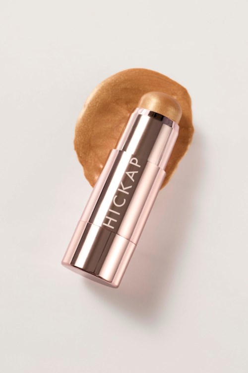 Ett läppstift i rör med ordet HICKAP på och en beige läppstiftsfärg. Det ligger på en persikofärgad makeupsvamp.