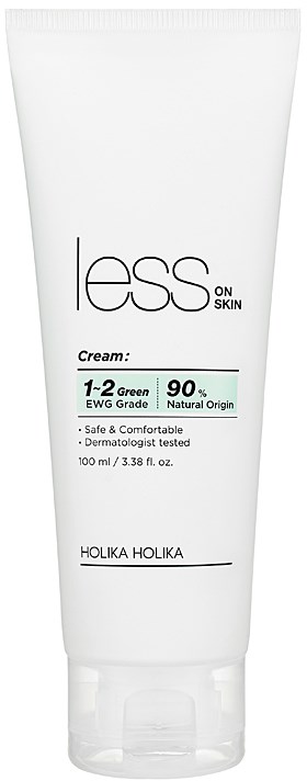 En hvit tube med hudkreme med svart og grønn tekst, merket "less on SKIN," inneholder informasjon om fordelene.
