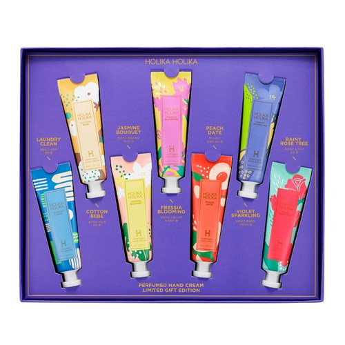 A box contains eight colorful tubes of hand cream with floral and nature-themed packaging. Each tube has a different scent name.