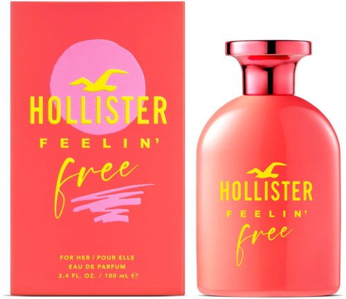 Różowa butelka perfum i pudełko z żółtym tekstem i logo ptaka, oznaczone Hollister Feelin' Free.
