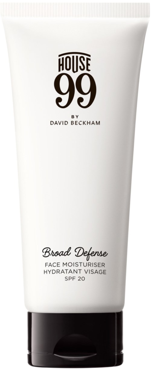 En vit tub med ansiktsfuktkräm märkt 'House 99 av David Beckham' med SPF 20, svart lock och enkel textdesign.