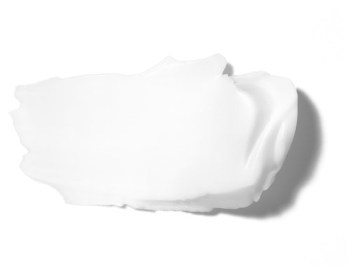 A blob of white cream or lotion with a shadow on a white background.