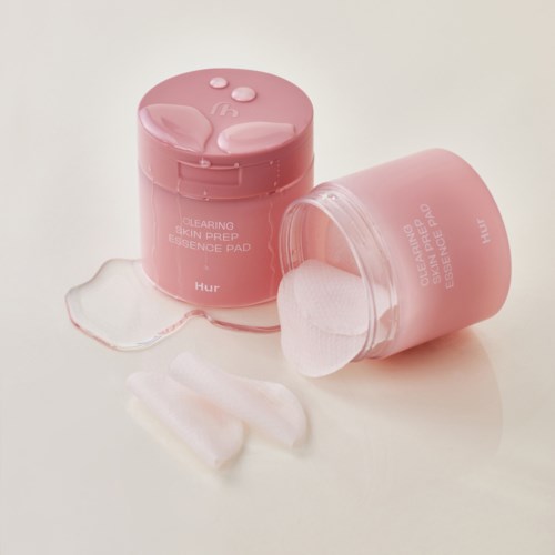 Two pink containers of skin prep pads, one open with pad pieces around, on a white background.