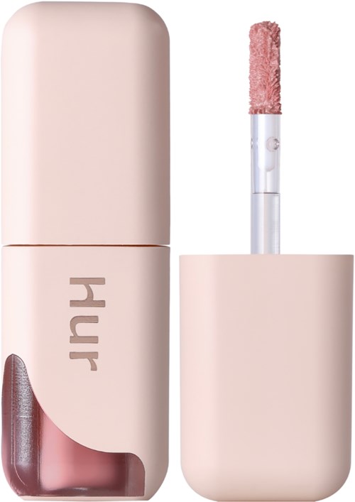 En fuktstift med ett rosa fall och en borste med rosa puder för makeup.