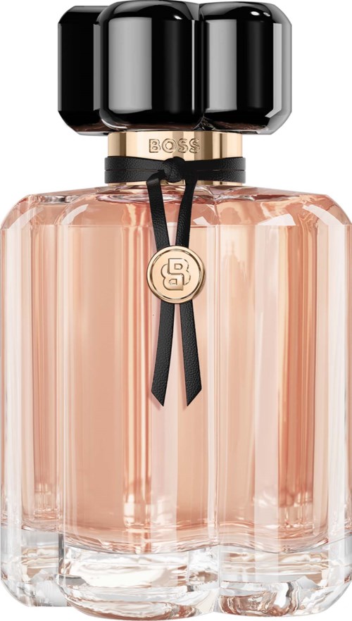 A pink perfume bottle with a black cap and a decorative ribbon. The bottle has a gold pendant with a logo.