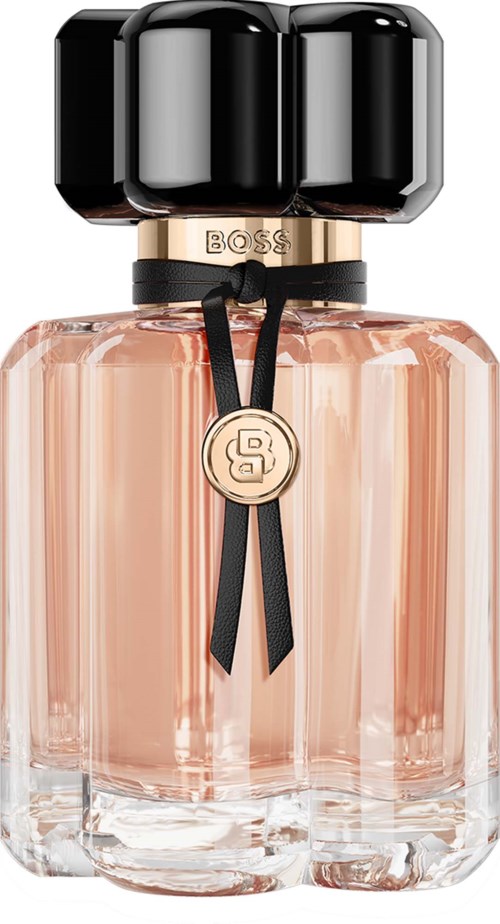 A luxurious perfume bottle with a black cap, gold accents, and a pink-tinted glass body adorned with a black ribbon.
