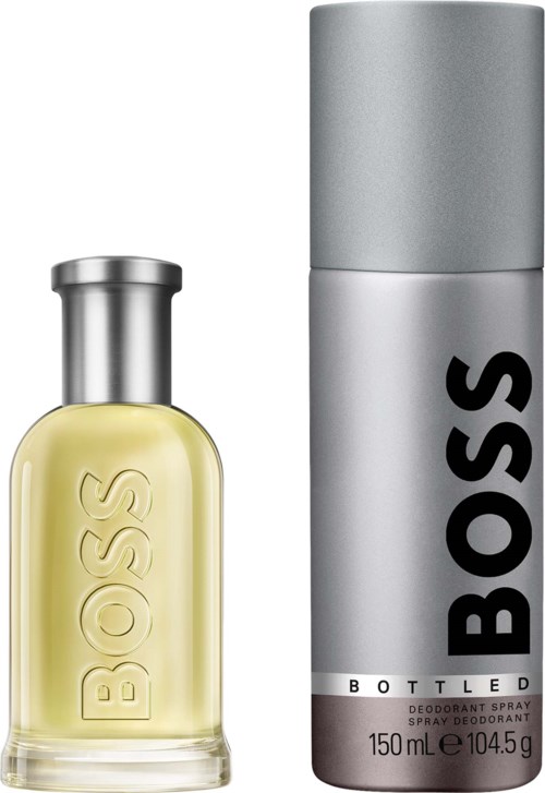 Een BOSS parfumfles met gele vloeistof en een metalen dop naast een lange zilveren BOSS deodorant spray.