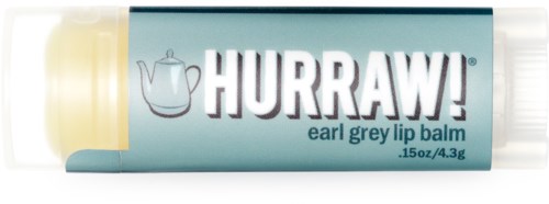 Een lipbalsemtube gemerkt 'HURRAW!' met een theepot en de naam 'earl grey,' in lichtblauwe verpakking.