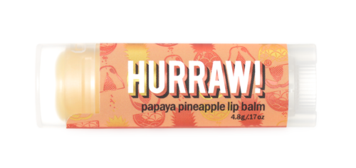 En liten tub med papaya- och ananasläppbalsam med en färgglad etikett och vit kork.