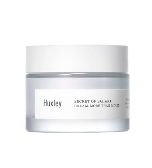 En lille glas med Huxley hudplejecreme mærket 'Secret of Sahara' med hvid låg og enkel design.