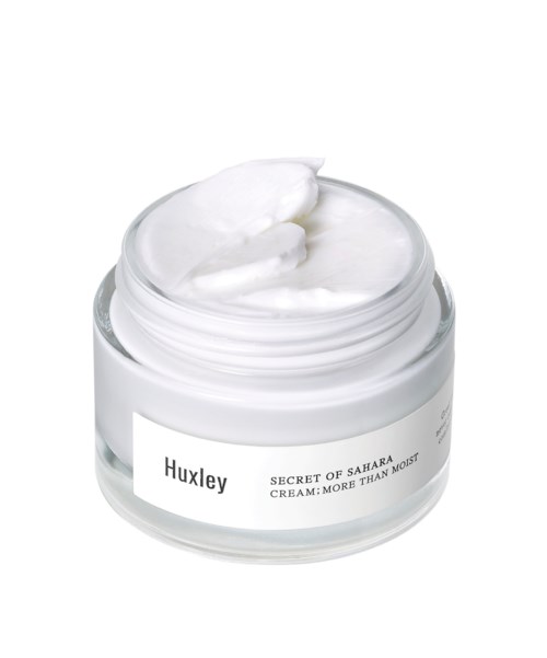 En krukke med hvid creme med lidt på toppen, mærket "Huxley" og "Secret of Sahara."