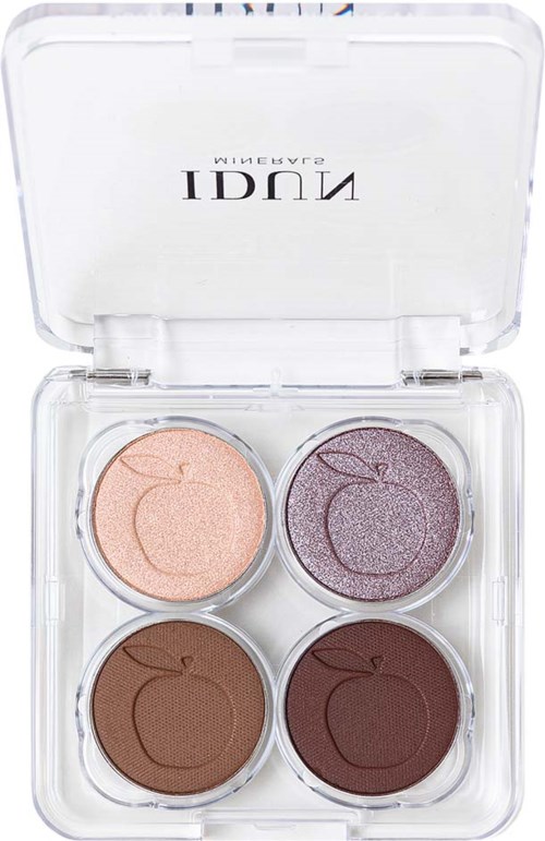 A clear plastic case contains four round eyeshadow pans in peach, purple, brown, and dark brown shades. The lid is open.