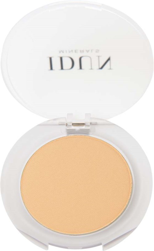 Een compacte met beige poeder, een open witte deksel met zwarte tekst, waarschijnlijk voor make-up.