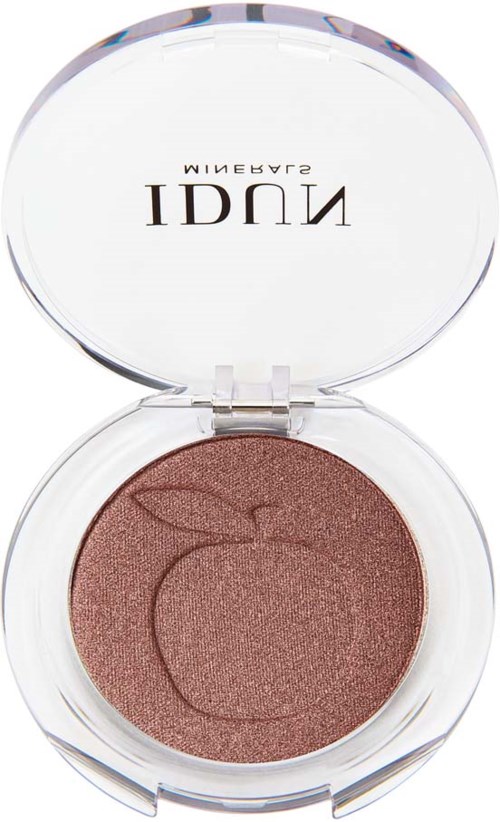 A round makeup compact with a peach-shaped design embossed on the brown powder inside.