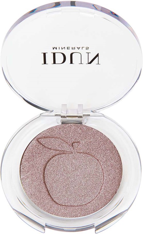 A round makeup compact with a light pink shimmer powder inside. The lid has a mirrored surface and text.