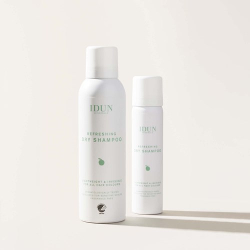 Two white bottles labeled IDUN Refreshing Dry Shampoo, with green text and a small green leaf, on a plain background.