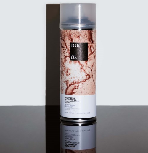 Pitkä, sylinterimäinen tölkki, jossa läpinäkyvä muovikansi, ja merkintä IGK Jet Lag shampoo kuiville hiuksille.