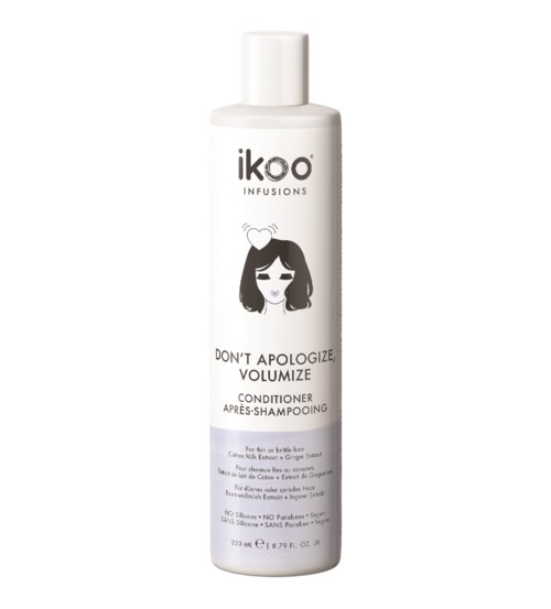 En vit flaska med Ikoo infusions balsam för lockigt hår, med en bild av en flicka och text om volym.