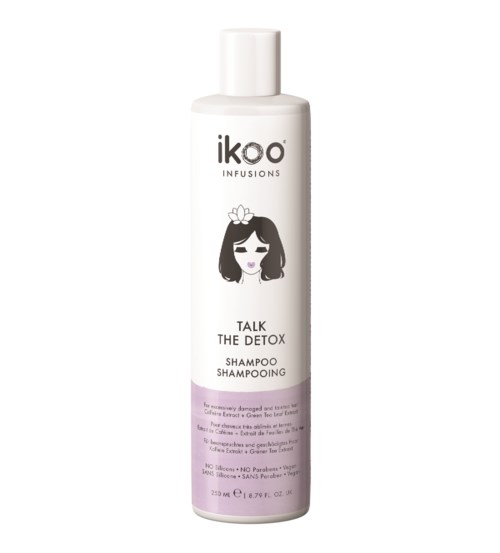 En vit flaska med Ikoo-schampo med en flicka-illustration och lila etikett, för hårtvätt och detox.