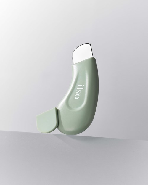 A green and white hearing aid device is floating against a plain background.