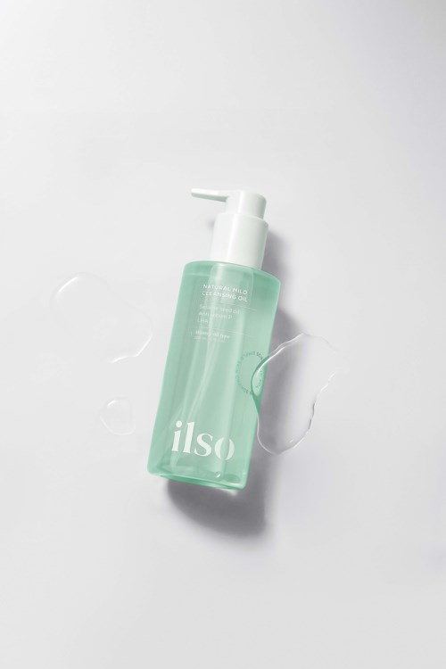 A clear green bottle with a pump, labeled "also," on a white background with some spilled liquid.