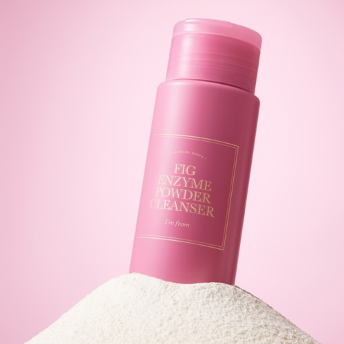 En rosa flaske mærket 'Fig Enzyme Powder Cleanser' står på pulver med lyserødt baggrund.