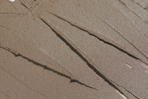 Flera zigzag-hål i en brun, grov yta. Inga andra föremål eller detaljer är synliga.