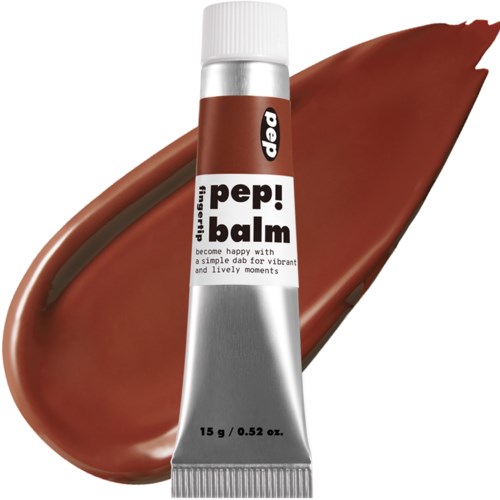 Lippenpflegestift mit brauner Farbe und Etikett, neben einem braunen Lippenbalsam-Teppich.