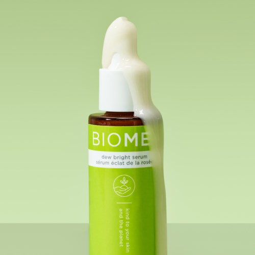 En brunt glasflaska med en grön och vit etikett, toppad med pipett, innehåller serum.