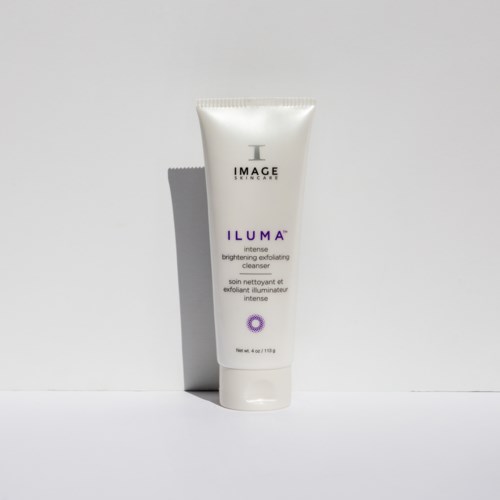 En hvit tube med hudpleieprodukt kalt ILUMA, fra IMAGE skincare, med lilla tekst. Enkel bakgrunn, frontvisning.