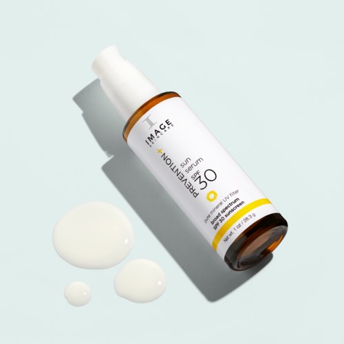 Flaskor med solskyddsserum med SPF 30 och krämdroppar på ljus bakgrund.