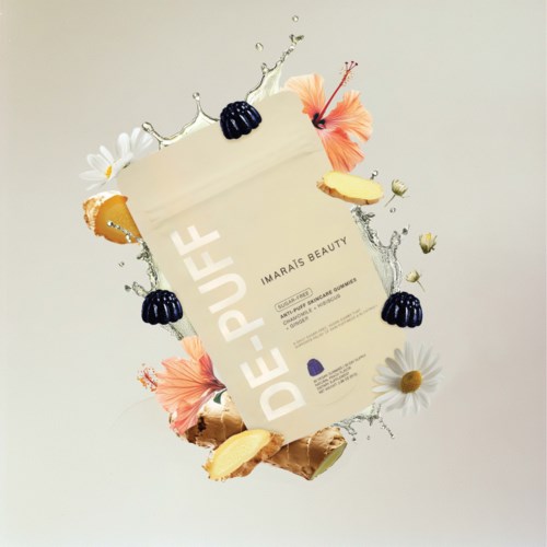 En skønhedsprodukt flyer omgivet af blomster, is og vandstænk. Flyer har ordene "DE-PUFF" og "IMARAIS BEAUTY."