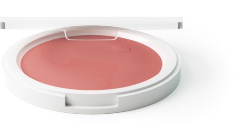 En rund, öppen behållare med rosa rouge inuti och ett vitt lock i närheten.