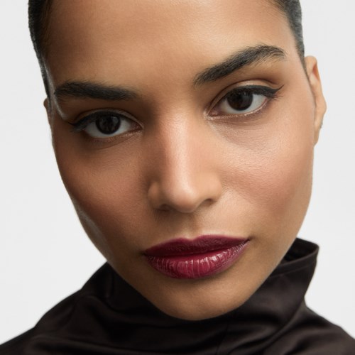 Närbild av en kvinnas ansikte med makeup, markerade läppar och subtil ögonmakeup.