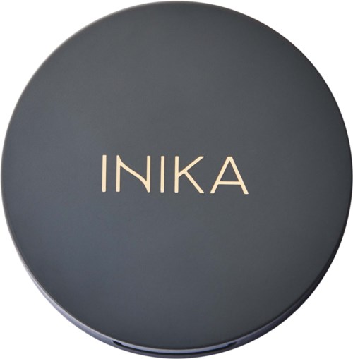 A round dark gray container with the word INIKA in cream-colored letters on top.