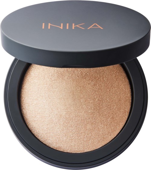 Et kompakt makeupprodukt, sandsynligvis en highlighter eller øjenskygge, i en sort rund beholder med guldglans.