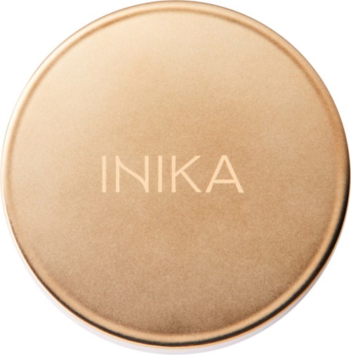 Eine runde, beigenfarbene Make-up-Compact mit dem Wort INIKA.