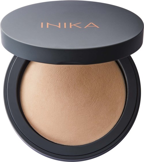 Ein Make-up-Puder in einer schwarzen Dose mit Deckel, beschriftet 'INIKA.'