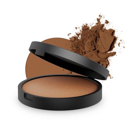 En compact med pressad bruns-liknande makeup med lock öppet och lite puder spillt utanför.