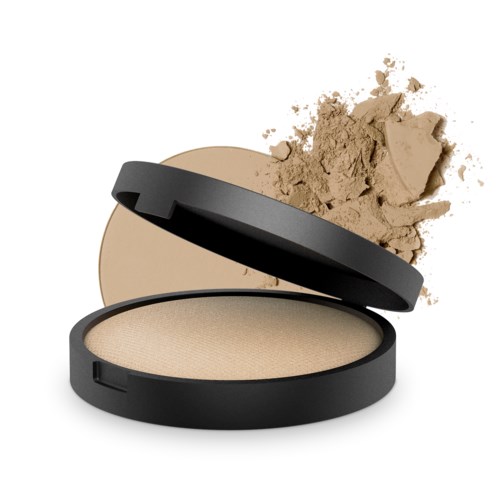 En liten makeuppuder-ask med pressat puder inuti och lite lös puder spillt i närheten.