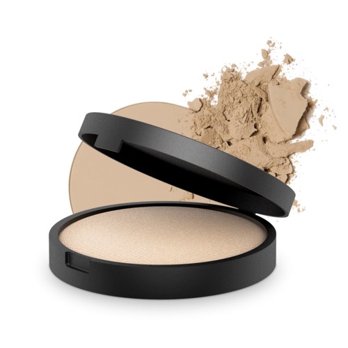 Ett runt lock med beige puder och locket öppet, med mer puder delvis spillt runt.