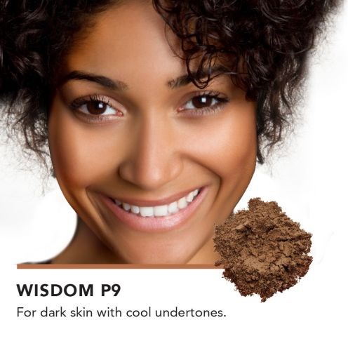 En leende kvinna med mörk hud och lockigt hår visas med en hög av brunt pulver, troligen makeup. Text nämner "WISDOM P9" för mörk hud.