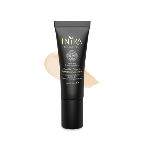 En svart tub med INIKA organisk concealer med en beige kräm bredvid.