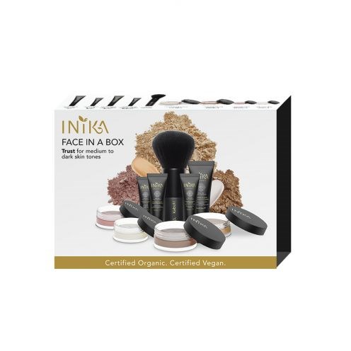 Samling av makeupprodukter, inklusive puder, krämer och borstar, för mörkare hudtoner.